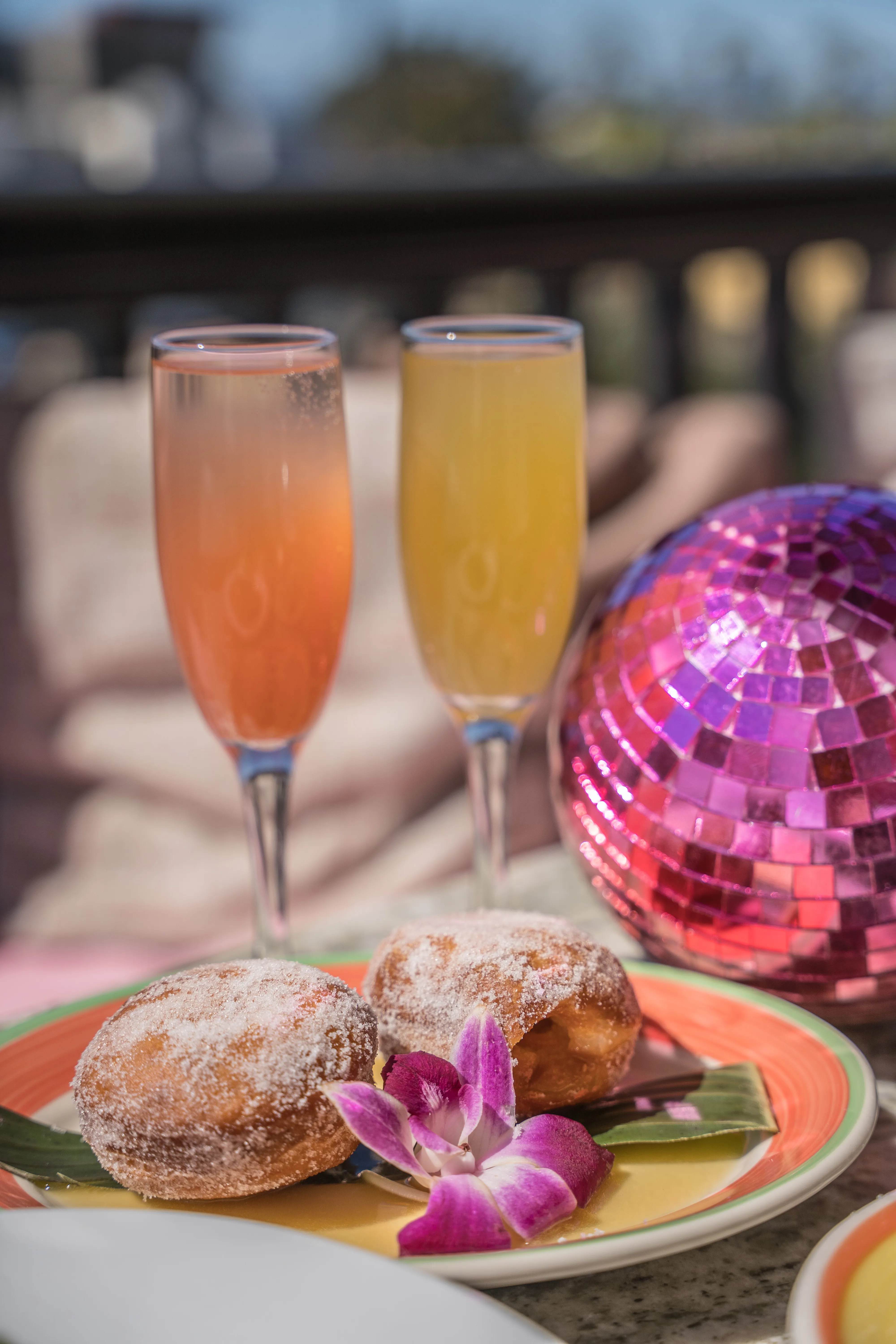 Portuguese malasadas dusted with sugar served with mimosas and pink disco ball