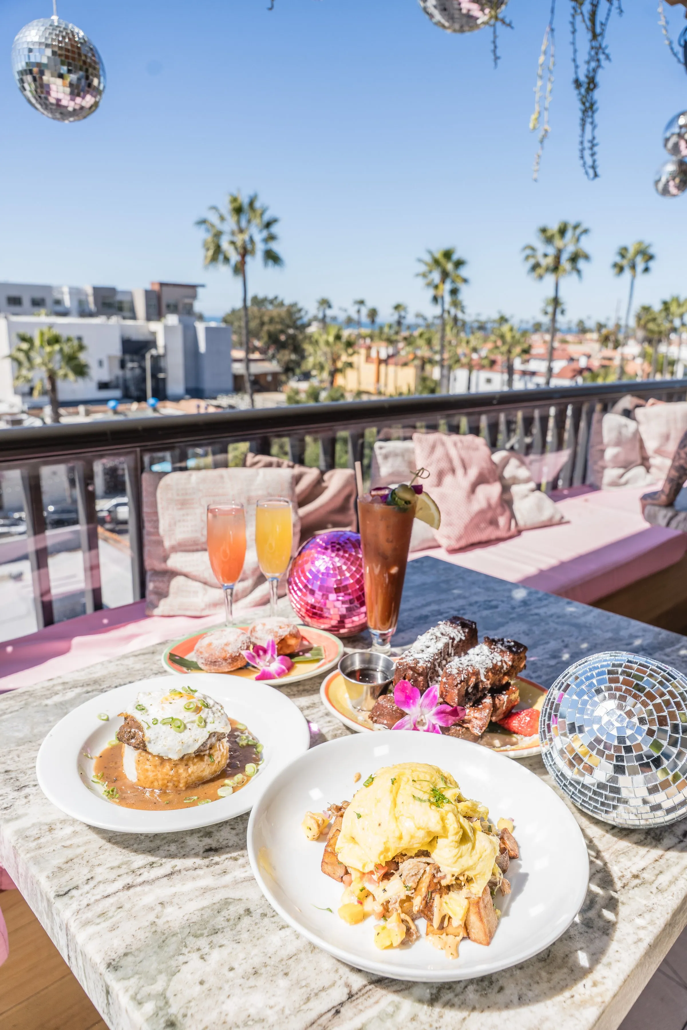 Coco Cabana rooftop brunch setup with disco balls, mimosas, and palms